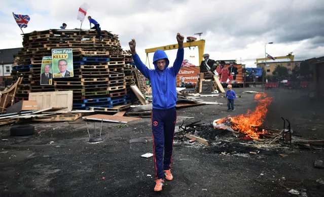 Loyalists make final preparations to their bonfire on the Newtownards road on July 11, 2016 in Belfast, Northern Ireland. The lighting of the bonfires at midnight on the eleventh night marks the start of the annual twelfth of July celebrations within the protestant community. The Orange marches and demonstrations celebrate the Battle of the Boyne in 1690 when the Protestant King William of Orange defeated the Catholic King James II on the banks of the river Boyne. (Photo by Charles McQuillan/Getty Images)