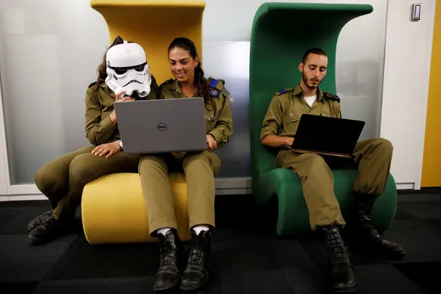 Israeli soldiers, one wearing a Star Wars Storm Trooper Voice Changing Helmet, work on laptops as they take part in a cyber security training course, called a Hackathon, at iNT Institute of Technology and Innovation, at a high-tech park in Beersheba, southern Israel August 28, 2017. (Photo by Amir Cohen/Reuters)