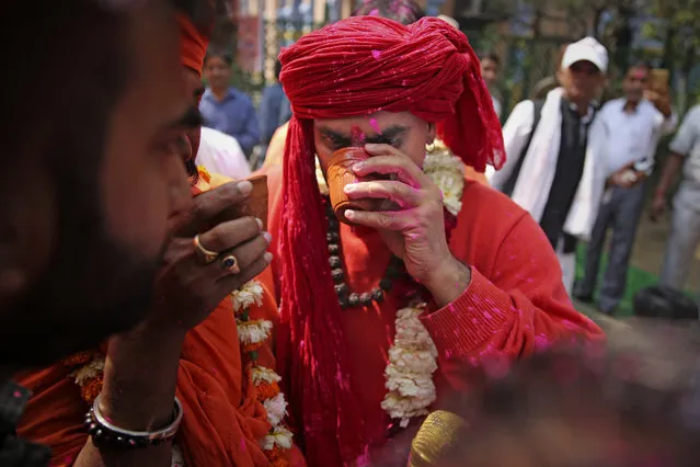 National president of Akhil Bhartiya Hindu Mahasabha Swami Chakrapani Maharaj drinks cow urine during an event organized by a Hindu religious group to promote consumption of cow urine as a cure for the new coronavirus in New Delhi, India, Saturday, March 14, 2020. The vast majority of people recover from the new coronavirus. According to the World Health Organization, people with mild illness recover in about two weeks, while those with more severe illness may take three to six weeks to recover. (Photo by Altaf Qadri/AP Photo)