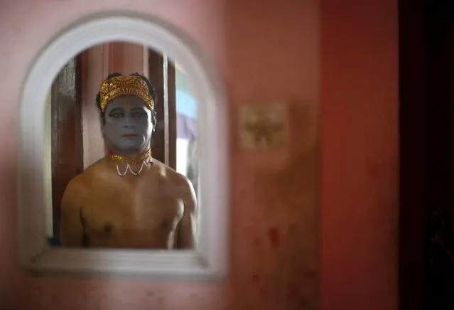 A reveller depicting Lord Krishna, a Hindu deity, is reflected in a mirror as he stands in a doorway before taking part in a LGBT (lesbian, gay, bisexual, and transgender) pride parade to mark Gaijatra Festival, also known as the festival of cows, in Kathmandu, Nepal August 30, 2015. (Photo by Navesh Chitrakar/Reuters)