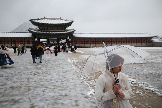A woman wearing Korean traditional costume Hanbok walks during heavy snow fall at Gyeongbok palace in central Seoul, South Korea, on November 27, 2024. (Photo by Kim Hong-Ji/Reuters)