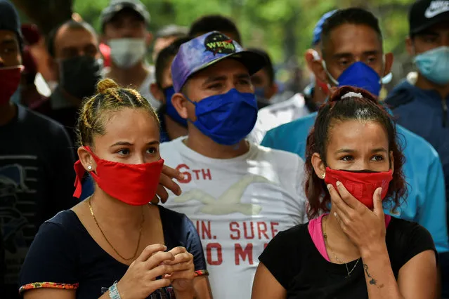 Venezuelan migrants wear face masks as they wait to be checked by health workers to rule out the novel coronavirus as part of their repatriation process in Cali, Colombia on April 13, 2020. The Mayor of Cali, Jorge Ivan Ospina, announced Sunday a “humanitarian corridor” was started to repatriate Venezuelan migrants. (Photo by Luis Robayo/AFP Photo)