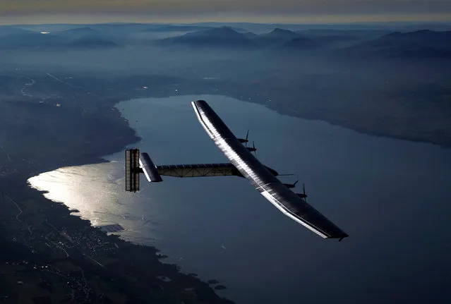 German test pilot Markus Scherdel steers the solar-powered Solar Impulse 2 aircraft over the Lake Neuchatel during a training flight at its base in Payerne, September 27, 2014. (Photo by Denis Balibouse/Reuters)