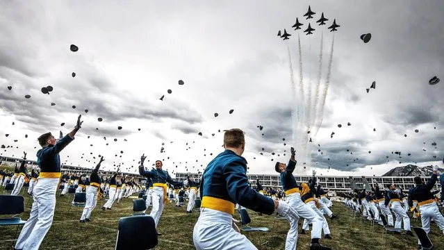Spaced eight feet apart, United States Air Force Academy cadets celebrate their graduation as a team of F-16 Air Force Thunderbirds fly over the academy on April 18, 2020 in Colorado Springs, Colorado. After senior cadets spent more than a month on lockdown in the Air Force Academy's dorms due to the coronavirus pandemic, Saturday's graduation, which was moved up by six weeks, marks the first time a military academy is graduating a class early since WWII. (Photo by Michael Ciaglo/Getty Images)