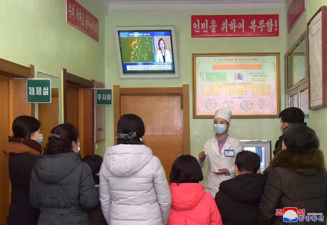 A photo released by the official North Korean Central News Agency (KCNA) shows a health worker speaking to people about the Covid-19 and coronavirus, in Pyongyang, Democratic People's Republic of Korea, 15 February 2020. (Photo by KCNA/EPA/EFE)