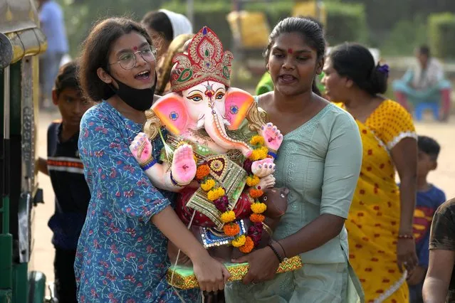Devotees carry an idol of the elephant-headed Hindu god Ganesh to immerse it in an artificial pond on the final day of the ten-day long Ganesh Chaturthi festival in Ahmedabad, India, Friday, September 9, 2022. The festival is a celebration of the birth of Ganesha, the Hindu god of wisdom, prosperity and good fortune. (Photo by Ajit Solanki/AP Photo)