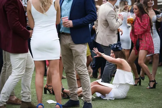 A reveller takes a tumble during Caulfield Cup Day at Caulfield Racecourse on October 21, 2017 in Melbourne, Australia. (Photo by Splash News and Pictures)