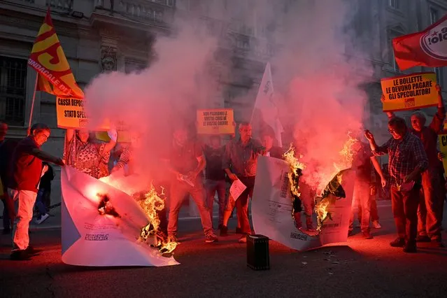 Protestors burn up their energy bills during a demonstration organized by Italian's Unione Sindacale di Base (USB) against the high cost of living and energy price rising in Rome on October 3, 2022. (Photo by Alberto Pizzoli/AFP Photo)