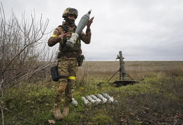 A Ukrainian National guard soldier prepares to fire at Russian positions with a mortar near Kharkiv, Ukraine, Tuesday, October 25, 2022. (Photo by Andrii Marienko/AP Photo)