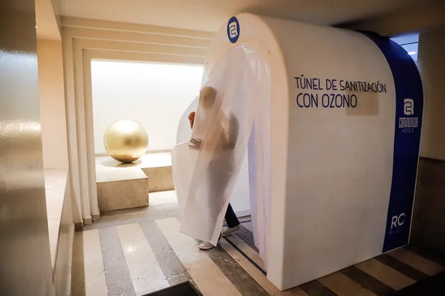 A man passes an ozone-based sanitation tunnel in the Camino Real Hotel in Mexico City, Mexico, July 2, 2020. (Photo by Chine Nouvelle/SIPA Press/Rex Features/Shutterstock)