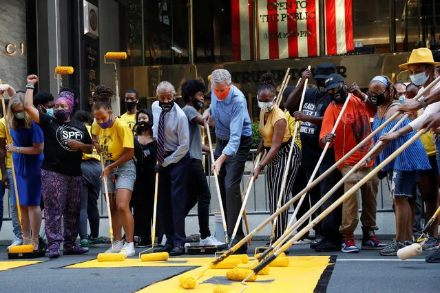 New York City Mayor Bill de Blasio, his wife Chirlane Irene McCray and Reverend Al Sharpton paint "Black Lives Matter" along 5th avenue with others outside Trump Tower in the Manhattan borough of New York City, New York, U.S., July 9, 2020. (Photo by Shannon Stapleton/Reuters)