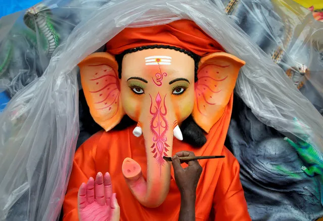 An artisan paints an idol of Hindu god Ganesh, the deity of prosperity, at a workshop ahead of the Ganesh Chaturthi festival, in Bengaluru, India August 30, 2016. (Photo by Abhishek N. Chinappa/Reuters)