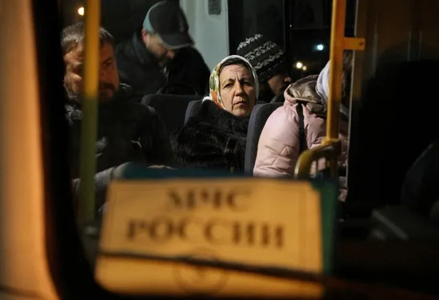 Civilians evacuated from the Russian-controlled part of Kherson region of Ukraine sit inside a bus as they arrive at a local railway station in the town of Dzhankoi, Crimea on November 10, 2022. (Photo by Alexey Pavlishak/Reuters)