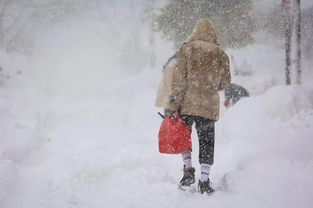 A man walks on the street with a gasoline can during a snowstorm as extreme winter weather hits Buffalo, New York, U.S., November 18, 2022. (Photo by Lindsay DeDario/Reuters)