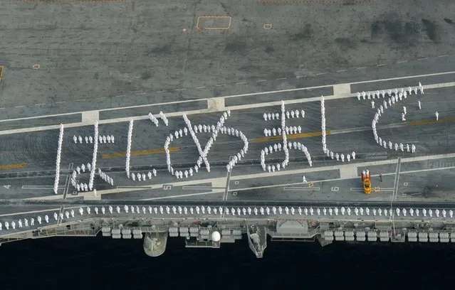 U.S. sailors on the deck of the USS Ronald Reagan, a Nimitz-class nuclear-powered super carrier, forms words in the Japanese phonetic alphabet meaning loosely in English "Nice to meet you"  upon the carrier arrives at the U.S. naval base in Yokosuka, south of Tokyo, Japan, in this aerial view photo taken by Kyodo October 1, 2015. (Photo by Reuters//Kyodo News)