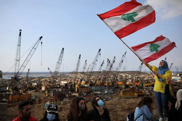 A demonstrator waves the Lebanese flag during protests near the site of the blast at the Beirut's port area, Lebanon on August 11, 2020. (Photo by Alkis Konstantinidis/Reuters)