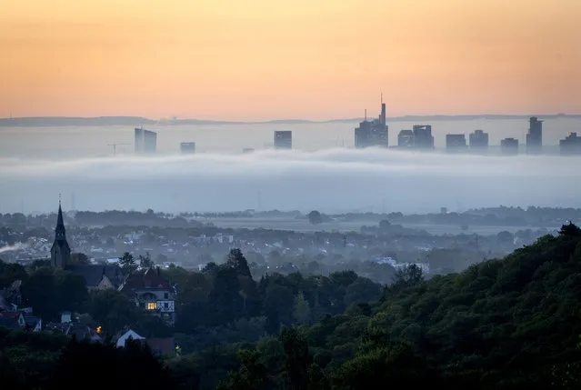 Fog surrounds buildings of the banking districts in Frankfurt, Germany, early Wednesday, September 21, 2022. In foreground the city of Kronberg. (Photo by Michael Probst/AP Photo)