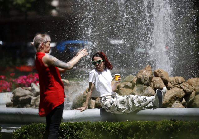 Two women enjoy the fountain at Zrinjevac Park in downtown Zagreb, Croatia, 04 June 2025. In the last few days, Croatia and Zagreb have experienced warmer weather with temperatures exceeding 32 degrees Celsius. (Photo by Antonio Bat/EPA/EFE)