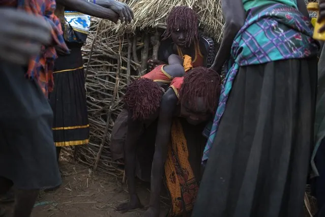 Pokot girls are encouraged to leave their hut and make their way to a place where they will take off their clothes and wash during their circumcision ceremony in a village about 80 kilometres from the town of Marigat in Baringo County, October 16, 2014. (Photo by Siegfried Modola/Reuters)