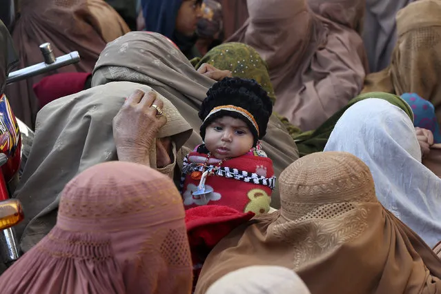 People stand in a long queue and wait to buy subsidized sacks of wheat flour in Peshawar, Pakistan, Monday, January 9, 2023. People are suffering from recent price hike in wheat flour in Pakistan. (Photo by Muhammad Sajjad/AP Photo)