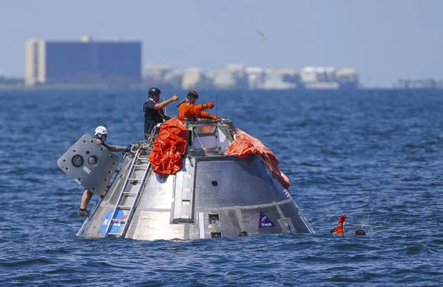 In this Thursday, July 13, 2017 photo, NASA astronaut Victor Glover signals back up to astronaut Daniel Burbank that he is OK after jumping into the Gulf of Mexico from the Orion capsule the astronauts are using to practice an emergency egress situation during recovery testing about four miles off of Galveston Island, Texas. The testing is the first time since the Apollo program that NASA has practiced such egress techniques from a capsule in open water. (Photo by Mark Mulligan/Houston Chronicle via AP Photo)