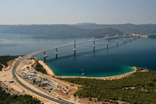 An aerial view of the newly built Peljesac Bridge in Komarna, southern Croatia, Tuesday, July 26, 2022. Croatia is marking the opening of a key and long-awaited bridge connecting two parts of the country's Adriatic Sea coastline while bypassing a small part of Bosnia's territory. (Photo by AP Photo)