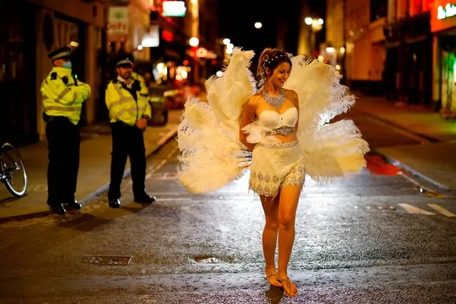 Drinkers leave the bars as police patrol in Soho, in central London on September 24, 2020 as the clock nears 10pm, on the first day of the new earlier closing times for pubs and bars in England and Wales, introduced to combat the spread of the coronavirus. Britain has tightened restrictions to stem a surge of coronavirus cases, ordering pubs to close early and advising people to go back to working from home to prevent a second national lockdown. (Photo by Tolga Akmen/AFP Photo)