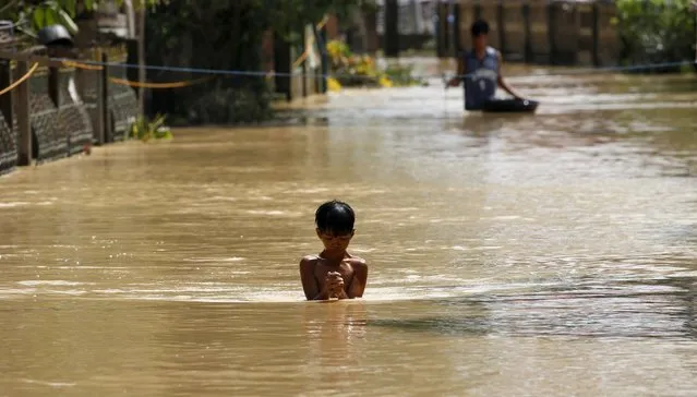 A boy wades through a flooded street in Jaen, Nueva Ecija in northern Philippines October 20, 2015, after the province was hit by Typhoon Koppu. (Photo by Erik De Castro/Reuters)