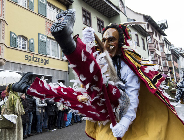A so-called Federahannes, a carnivalist of the tradiotal Swabian carnival, jumps with a stick during a parade in Rottweil, southwestern Germany, on Shrove Monday, February 12, 2018. (Photo by Patrick Seeger/DPA via AP Photo)