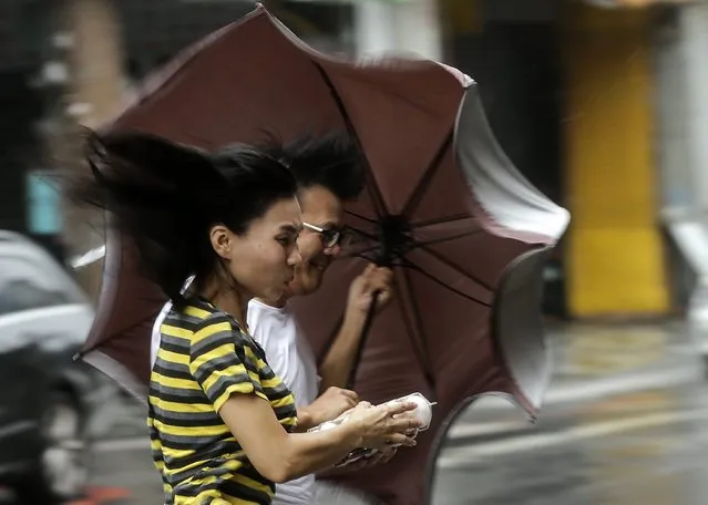 People brave to heavy rains and strong wind as typhoon Megi hits Hualien county, eastern Taiwan, 27 September 2016. Typhoon Megi hit Taiwan with heavy winds, causing coastal high waves and flooding rains, according to media reports. (Photo by Ritchie B. Tongo/EPA)