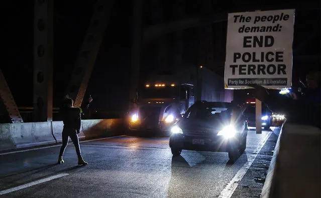A demonstrator tries to stop traffic along the Interstate 95 bridge during a protest over the death of Tyre Nichols, Friday, January 27, 2023, in Memphis, Tenn. Authorities released video footage Friday showing Nichols being beaten earlier this month by five Memphis police officers who held the Black motorist down and repeatedly struck him with their fists, boots and batons as he screamed for his mother. (Photo by Patrick Lantrip/Daily Memphian via AP Photo)