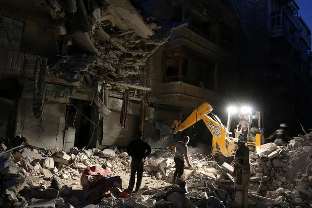 Civil Defense members search for survivors at a site hit by an airstrike in the rebel-held al-Shaar neighbourhood of Aleppo, Syria, September 27, 2016. (Photo by Abdalrhman Ismail/Reuters)