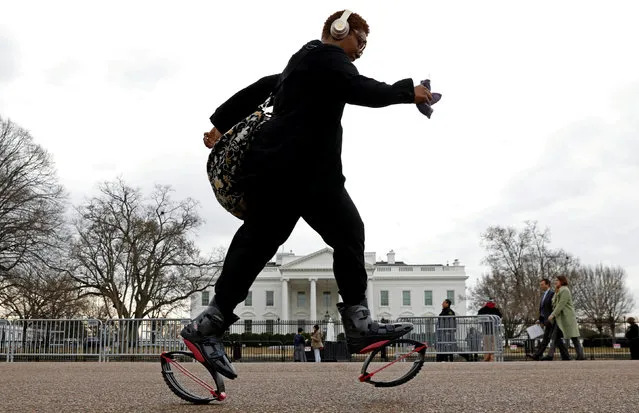 Wearing Kangoo jump boots, federal worker Tameka Green passes the White House as she exercises on her way to work during the government shutdown in Washington, U.S., January 22, 2018. (Photo by Kevin Lamarque/Reuters)