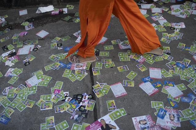 A woman walks on a path littered with electoral leaflets during municipal elections in the Rocinha slum in Rio de Janeiro, Brazil, Sunday, November 15, 2020. (Photo by Silvia Izquierdo/AP Photo)