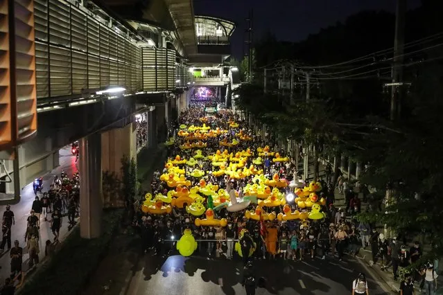Protesters march while carrying inflatable yellow ducks outside the headquarters of the 11th Infantry Regiment on November 29, 2020 in Bangkok, Thailand. Protesters marched to the headquarters of the Royal Thai Army's 11th Infantry Regiment, which also a King's Guard regiment. (Photo by Lauren DeCicca/Getty Images)