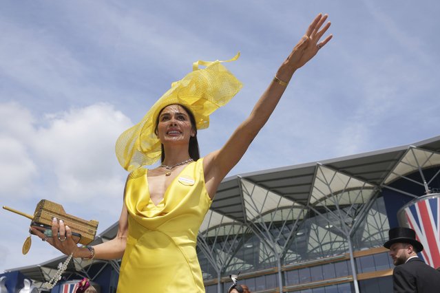 Zara Sassoon-Munns wearing bright yellow outfit gestures to a friend as she poses for a photograph on the second day of the Royal Ascot horse race meeting at Ascot, England, Wednesday, June 19, 2024. (Photo by Kin Cheung/AP Photo)