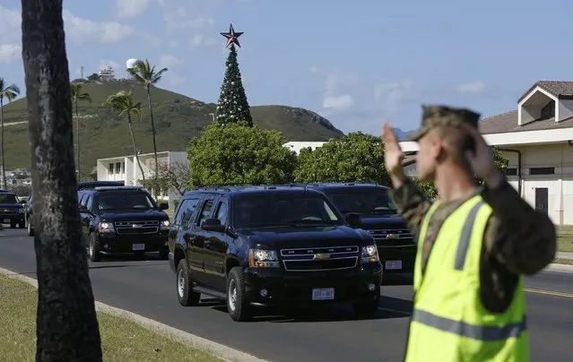 U.S. President Barack Obama's motorcade drives by a Christmas tree after his round of golf at Marine Corps Base Hawaii December 21, 2014. The President and his family are currently on their annual Christmas holiday season vacation. (Photo by Gary Cameron/Reuters)