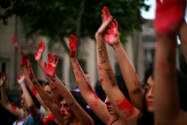 Demonstrators rise their painted hands during a peaceful march against gender violence in Santiago, Chile, October 19, 2016. (Photo by Ivan Alvarado/Reuters)