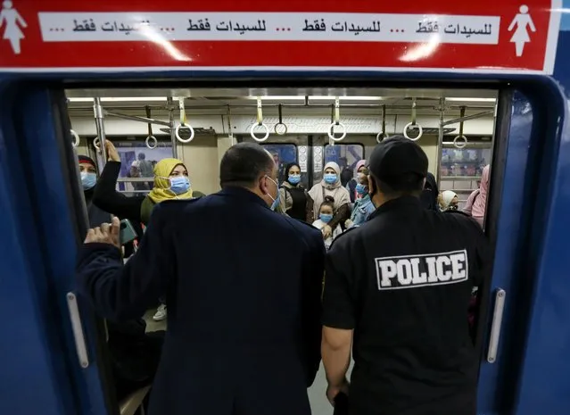 Police members check on passengers wearing protective face mask inside the underground Al Shohadaa “Martyrs” metro while Egypt ramps up its efforts to slow down the spread of the coronavirus disease (COVID-19) in Cairo, Egypt on November 21, 2020. (Photo by Mohamed Abd El Ghany/Reuters)