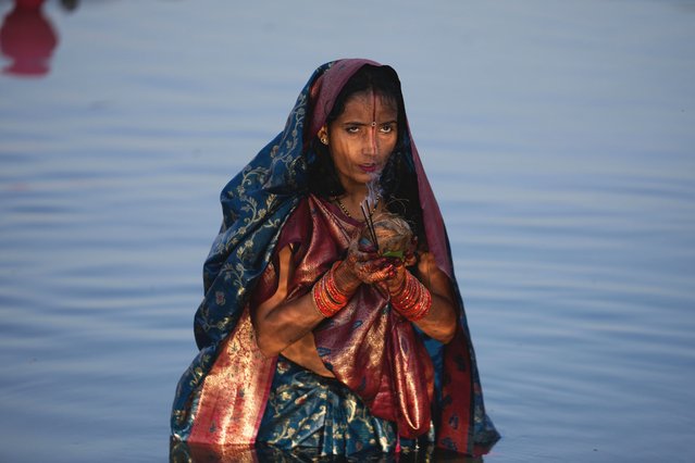 A Hindu devotee performs rituals at sunset on the banks of the Tawi River during Chhath Puja festival in Jammu, India, Monday, October 27, 2025. (Photo by Manish Swarup/AP Photo)