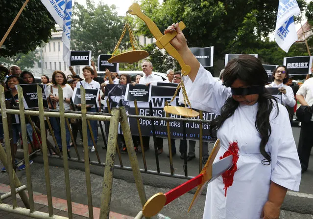 Lawyers display placards and shout slogans during a rally outside the Philippine Supreme Court to protest Friday's ouster of Philippine Supreme Court Chief Justice Maria Lourdes Sereno Tuesday, May 15, 2018 in Manila, Philippines. The Philippine Supreme Court ousted its chief justice, a critic of the country's authoritarian president, in an unprecedented vote Friday by fellow magistrates that she and hundreds of protesters called unconstitutional and a threat to democracy. (Photo by Bullit Marquez/AP Photo)