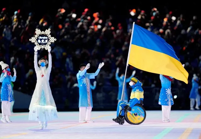 Maksym Yarovyi of Ukraine carries the flag during the opening ceremony at the 2022 Winter Paralympics, Friday, March 4, 2022, in Beijing. (Photo by Aly Song/Reuters)