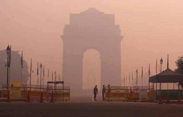 Security personnel stand guard in front of the India Gate amidst the heavy smog in New Delhi, India, October 31, 2016. (Photo by Adnan Abidi/Reuters)