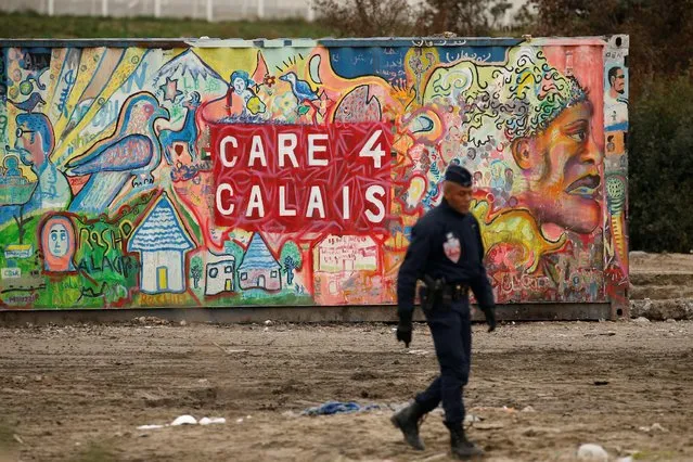A riot policemen patrols close to where some 1,500 migrant minors are being housed temporarily in converted shipping containers in Calais, France, November 1, 2016. (Photo by Pascal Rossignol/Reuters)