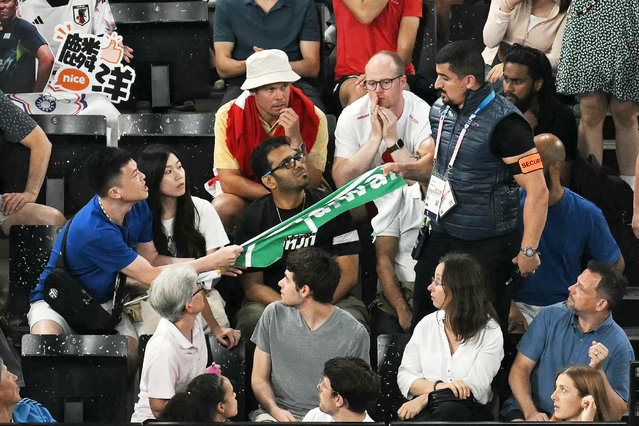 A security member removes a banner showing the name “Taiwan” from a fan in the audience during the men's doubles badminton semi-final match between Denmark and Taiwan in the Paris 2024 Olympic Games at Porte de la Chapelle Arena in Paris on August 2, 2024. (Photo by Arun Sankar/AFP Photo)
