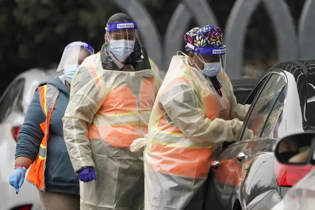 Workers administer a COVID-19 vaccine at a Los Angeles County site at the California State University Northridge, Tuesday, February 9, 2021, in Northridge, Calif. (Photo by Marcio Jose Sanchez/AP Photo)