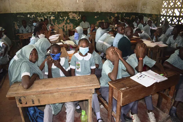 Pupils Concodia Primary school in Mombasa County, Kenya, Monday, January 4, 2021, as schools re-opened after a nine month break due to the COVID-19 pandemic. All Primary and secondary schools in the country were reopened in congested classes despite efforts by the national government to have fulfilled their promises of having new desks and new classes to avoid the social distance calamity which could cause the spread of the pandemic in schools. (Photo by Gideon Maundu/AP Photo)