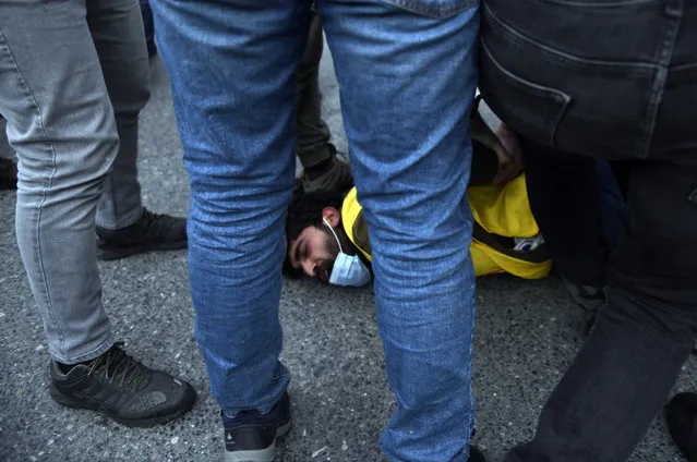 Turkish police officers arrest a youth during clashes with students of the Bogazici University protesting the appointment of a government loyalist to head their university, in Istanbul, Tuesday, February 2, 2021. For weeks, students and faculty at Istanbul's prestigious Bogazici University have been protesting President Recep Tayyip Erdogan's appointment of Melih Bulu, a figure who has links to his ruling party, as the university's rector. They have been calling for Bulu's resignation and for the university to be allowed to elect its own president. (Photo by Omer Kuscu/AP Photo)