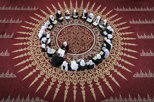 Palestinian Muslim girls sit together in a circle at a class for the recitation of the Koran, Islam's holy book, during a summer camp at a mosque in Gaza city on June 13, 2023. (Photo by Mahmud Hams/AFP Photo)