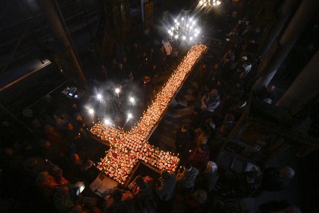 Believers light candles on a cross-shaped platform covered with candles attached to jars of honey during a ceremony marking the day of Saint Haralampi, Orthodox patron saint of beekeepers, at the Church of the Blessed Virgin in Blagoevgrad, eastern Bulgaria on February 10, 2025. (Photo by Nikolay Doychinov/AFP Photo)